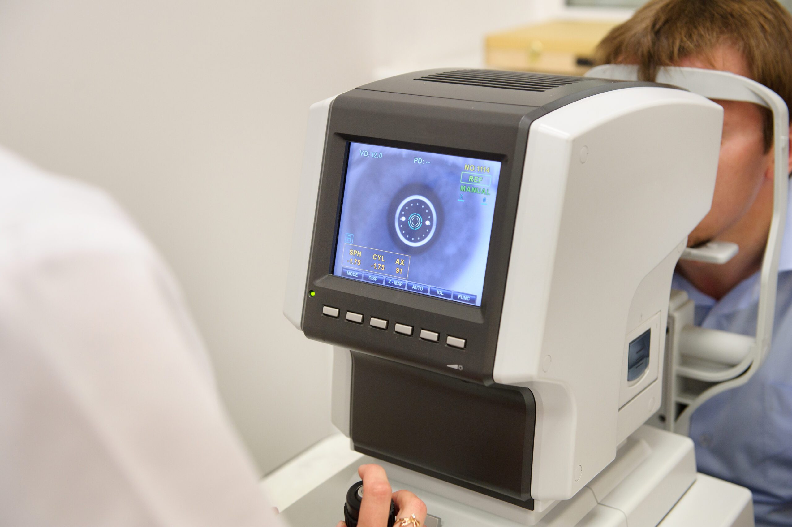 the optometrist controls the oculist display with the scanned eyes of the man, diagnostic ophthalmological equipment.