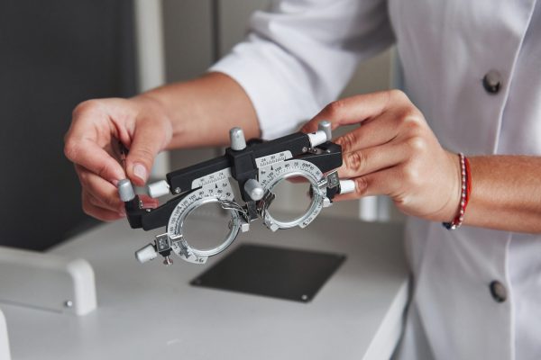 Female hands holding the optical device for eye testing.